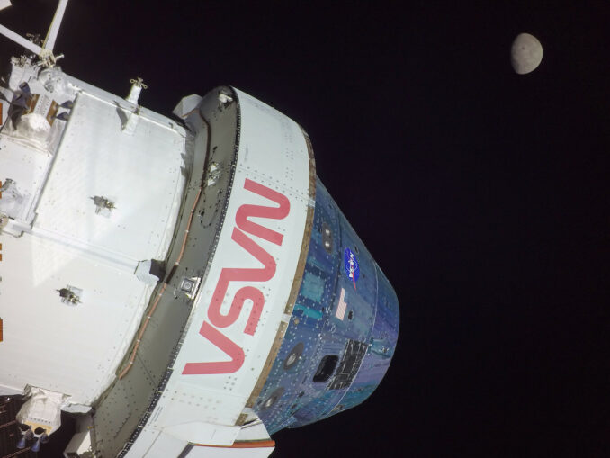 NASA's Orion spacecraft, pictured by a solar array wingtip camera, with the moon in the background. Credit: NASA