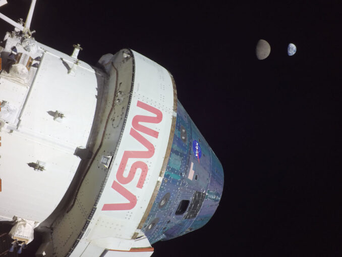 A camera on one of the Orion spacecraft's solar array wings captured this view of the crew module Monday, Nov. 28, with the Earth and the moon in the background. Credit: NASA