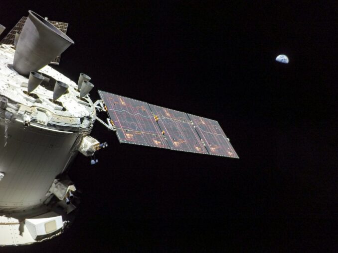A camera on one of the Orion spacecraft's solar arrays captured this view Nov. 30 of the Orbital Maneuvering System engine, a leftover from the space shuttle program. Earth is visible in the distance more than a quarter-million miles away. Credit: NASA